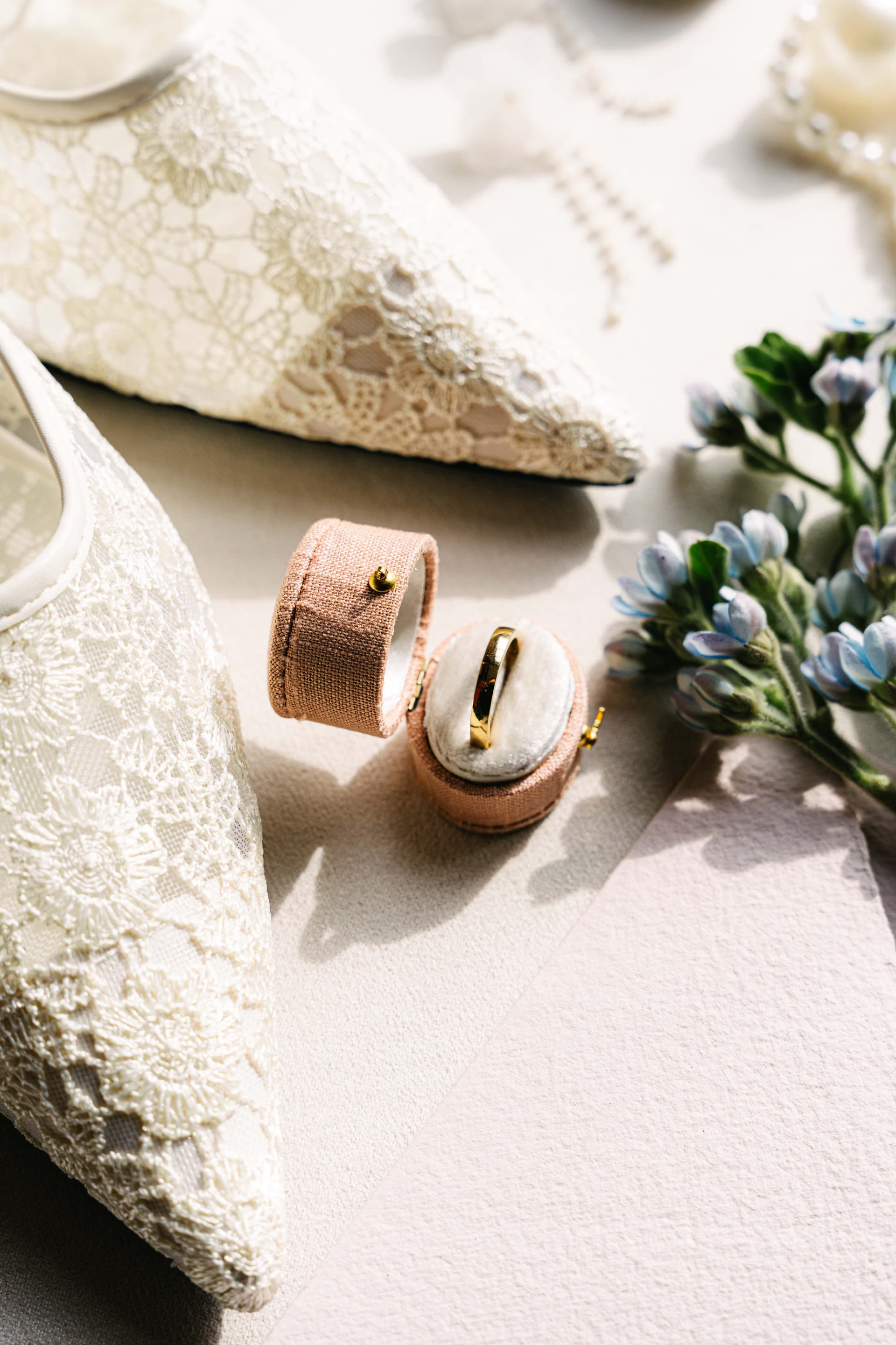 Goldring in Samtschachtel mit Spitzenschuhen und Blumen